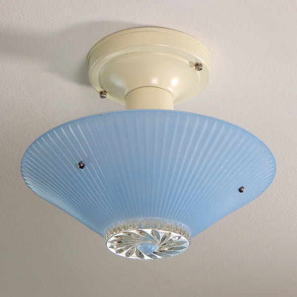 The semi-flush triple-beaded chain ceiling light fixture emerged with its earliest iterations in the 1920s through the 1940s. Triple-beaded chain fixtures of this period featured bold patterns and almost always had enameled finishes in pinks, blues, greens, whites, or bisque colors. The trend continued into the 1960s with less heavy-looking glass shades and silk-screened enameled finishes instead of the hand-painted enameled finish. Available at www.vintporium.com