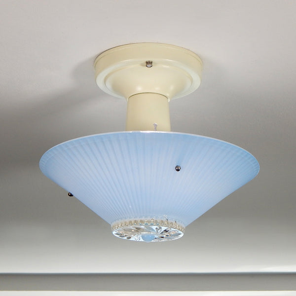 The semi-flush triple-beaded chain ceiling light fixture emerged with its earliest iterations in the 1920s through the 1940s. Triple-beaded chain fixtures of this period featured bold patterns and almost always had enameled finishes in pinks, blues, greens, whites, or bisque colors. The trend continued into the 1960s with less heavy-looking glass shades and silk-screened enameled finishes instead of the hand-painted enameled finish. Available at www.vintporium.com