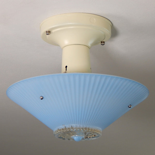 The semi-flush triple-beaded chain ceiling light fixture emerged with its earliest iterations in the 1920s through the 1940s. Triple-beaded chain fixtures of this period featured bold patterns and almost always had enameled finishes in pinks, blues, greens, whites, or bisque colors. The trend continued into the 1960s with less heavy-looking glass shades and silk-screened enameled finishes instead of the hand-painted enameled finish. Available at www.vintporium.com