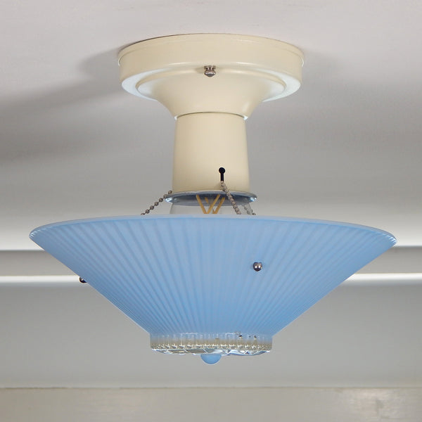The semi-flush triple-beaded chain ceiling light fixture emerged with its earliest iterations in the 1920s through the 1940s. Triple-beaded chain fixtures of this period featured bold patterns and almost always had enameled finishes in pinks, blues, greens, whites, or bisque colors. The trend continued into the 1960s with less heavy-looking glass shades and silk-screened enameled finishes instead of the hand-painted enameled finish. Available at www.vintporium.com