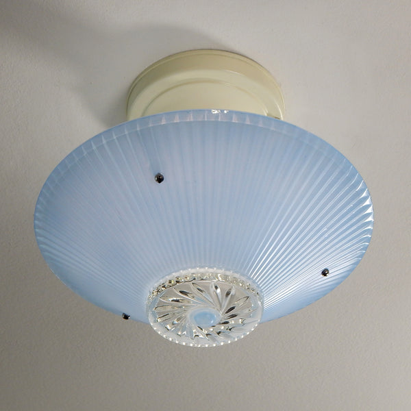 The semi-flush triple-beaded chain ceiling light fixture emerged with its earliest iterations in the 1920s through the 1940s. Triple-beaded chain fixtures of this period featured bold patterns and almost always had enameled finishes in pinks, blues, greens, whites, or bisque colors. The trend continued into the 1960s with less heavy-looking glass shades and silk-screened enameled finishes instead of the hand-painted enameled finish. Available at www.vintporium.com
