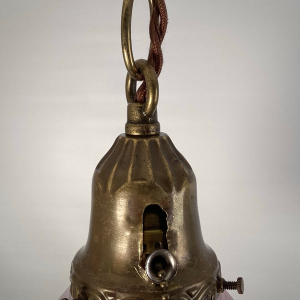 Close-up of the antique brass shade holder on a 1920s pendant light, showing the pull-chain socket, decorative trim, and fitter screws.