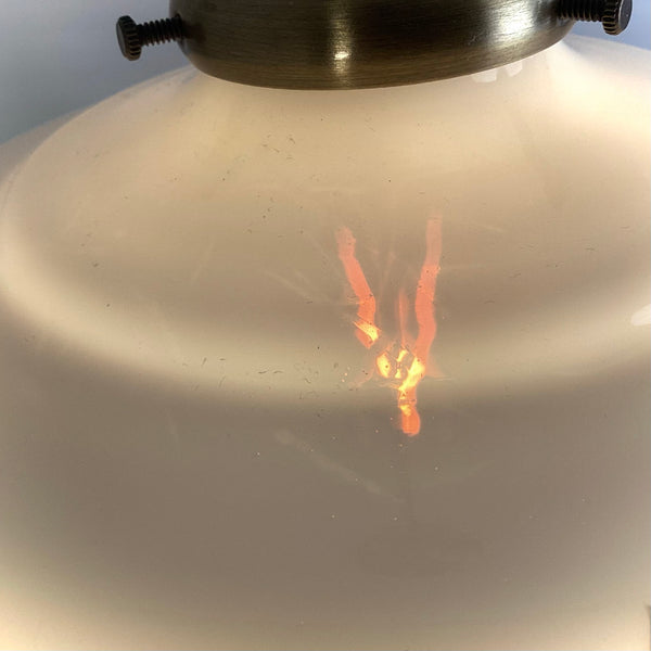 Close-up of the texture and soft light diffusion on a frosted Art Deco glass pendant shade.