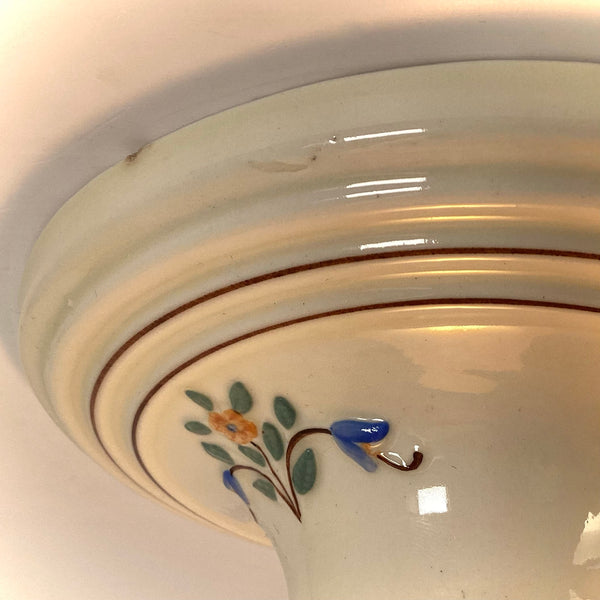Close up of hand painted floral motif on vintage porcelain ceiling light