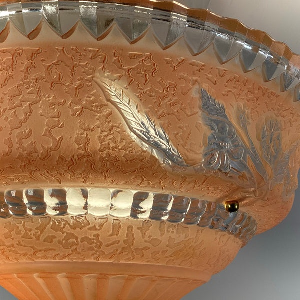 Close up detail of peach etched glass ceiling light showing leaf and flower motif