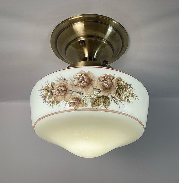 This semi-flush ceiling light features a vintage 1970s glass shade that combines hand-painted bands and a screen-printed floral motif. Screen printing is a technique widely used for applying designs and patterns onto various surfaces, including glass. In the 1970s, this method gained popularity due to its versatility and ability to produce high-quality, durable prints. Available at www.vintporium.com