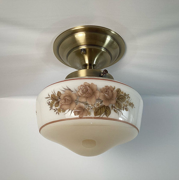 This semi-flush ceiling light features a vintage 1970s glass shade that combines hand-painted bands and a screen-printed floral motif. Screen printing is a technique widely used for applying designs and patterns onto various surfaces, including glass. In the 1970s, this method gained popularity due to its versatility and ability to produce high-quality, durable prints. Available at www.vintporium.com