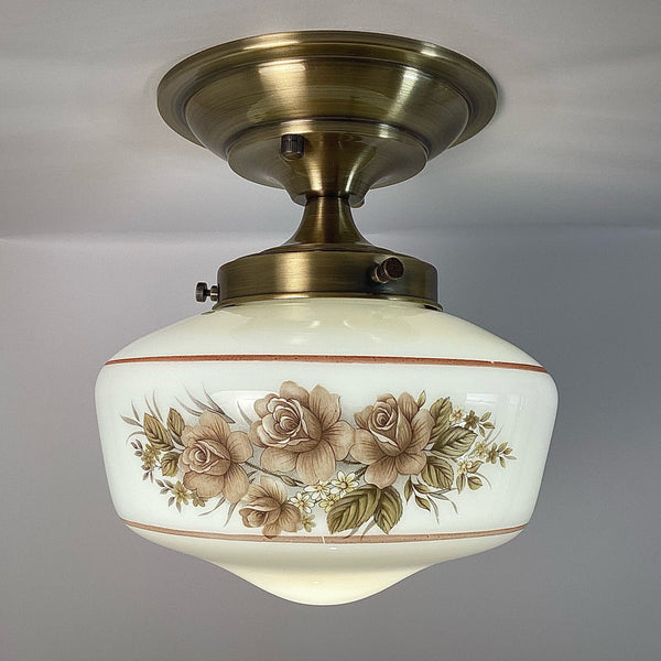 This semi-flush ceiling light features a vintage 1970s glass shade that combines hand-painted bands and a screen-printed floral motif. Screen printing is a technique widely used for applying designs and patterns onto various surfaces, including glass. In the 1970s, this method gained popularity due to its versatility and ability to produce high-quality, durable prints. Available at www.vintporium.com