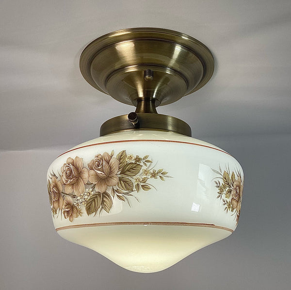 This semi-flush ceiling light features a vintage 1970s glass shade that combines hand-painted bands and a screen-printed floral motif. Screen printing is a technique widely used for applying designs and patterns onto various surfaces, including glass. In the 1970s, this method gained popularity due to its versatility and ability to produce high-quality, durable prints. Available at www.vintporium.com