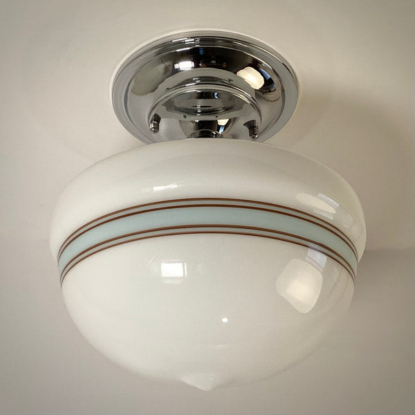 Classic schoolhouse style flush mount ceiling light with chrome hardware and striped opal glass, cool white light.