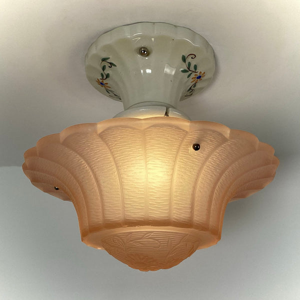 Illuminated 1930s peach Art Deco glass ceiling light glowing warmly