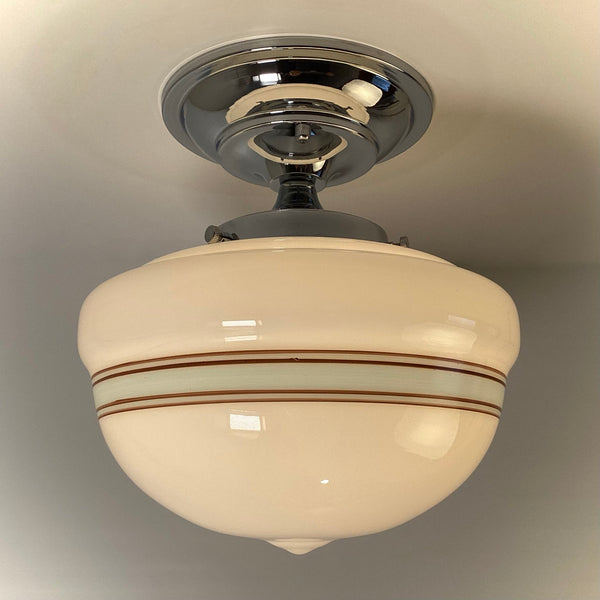 Semi-flush schoolhouse ceiling light with decorative chrome neck and banded glass shade, warm glow.