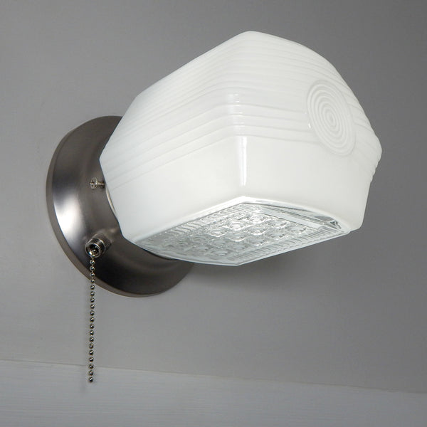 Close-up of enameled milk glass shade showing stepped Art Deco detailing and smooth satin nickel hardware.