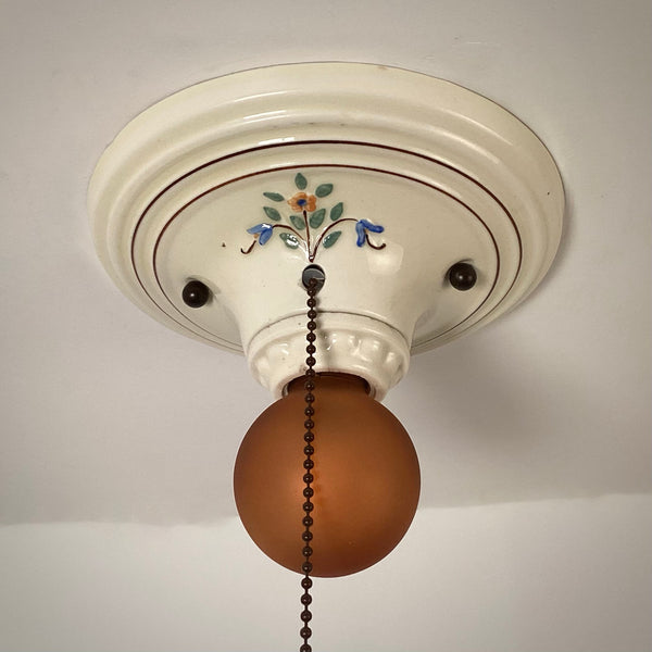 Hand painted porcelain ceiling light showing floral detail and pull chain off