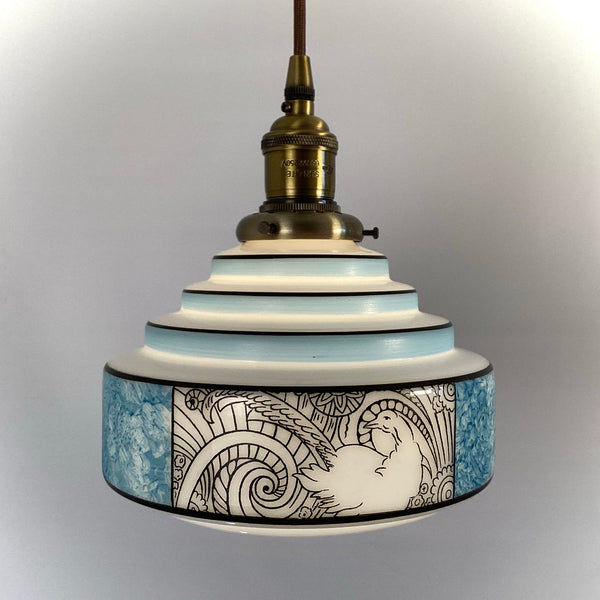 Close view of Art Deco glass shade featuring stylized pheasant and scrollwork pattern