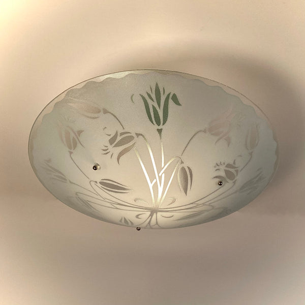 Underside view of a vintage etched glass bowl light fixture showing intricate tulip and leaf patterns.