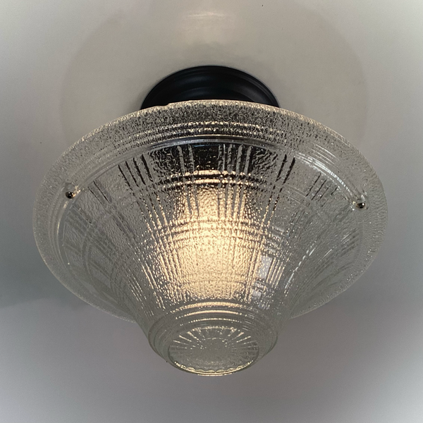 underside view of glowing vintage pressed glass ceiling light with charcoal semi-flush fixture