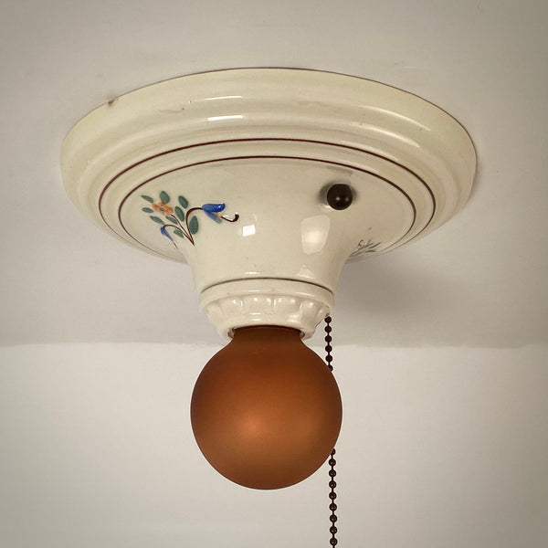 Side view of vintage porcelain ceiling light with hand painted floral design