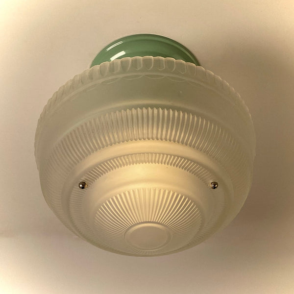 Vintage semi-flush ceiling light bottom view illuminated, displaying ribbed frosted glass diffuser