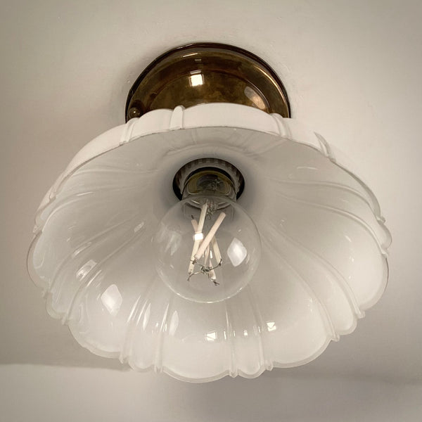 Brass flush mount ceiling light underside view with scalloped milk glass