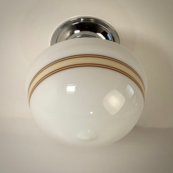 Underside view of mocha banded milk glass schoolhouse ceiling light globe
