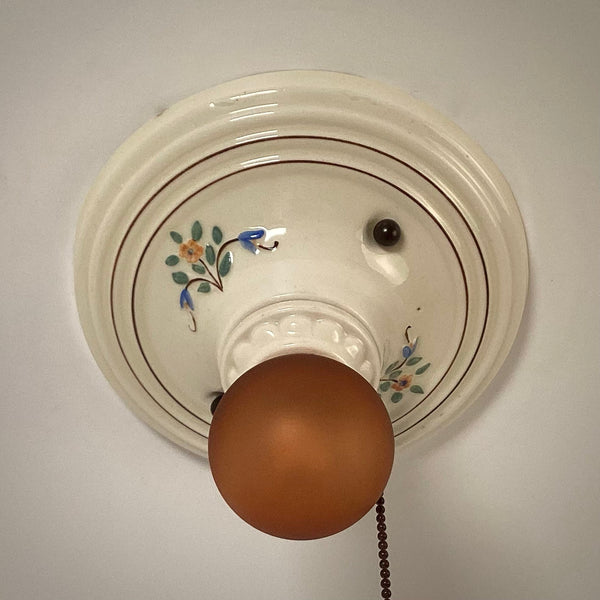 Top view of vintage porcelain ceiling light with painted floral motifs