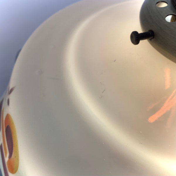 Macro shot of the hand-painted details and slight patina on a vintage 1930s style glass lamp shade.