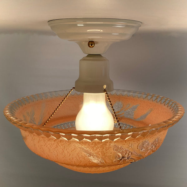 Side angle view of peach etched glass ceiling light showing floral band detail