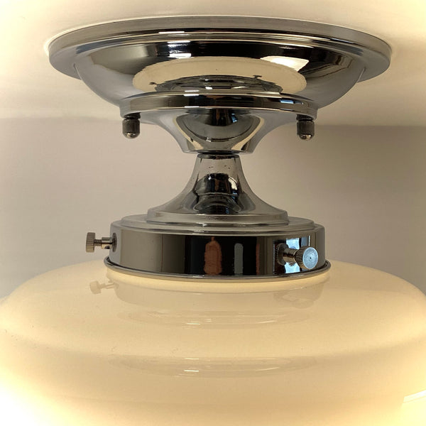 Close-up of polished chrome ceiling canopy and mounting hardware on schoolhouse light