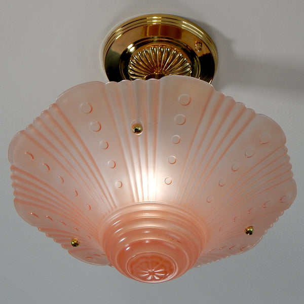 The semi-flush triple-beaded chain ceiling light fixture emerged with its earliest iterations in the 1920s through the 1940s. Triple-beaded chain fixtures of this period featured bold patterns and almost always had enameled finishes in pinks, blues, greens, whites, or bisque colors. The trend continued into the 1960s with lighter glass shades and silk-screened finishes instead of the hand-painted enameled finish. Available at www.vintporium.com