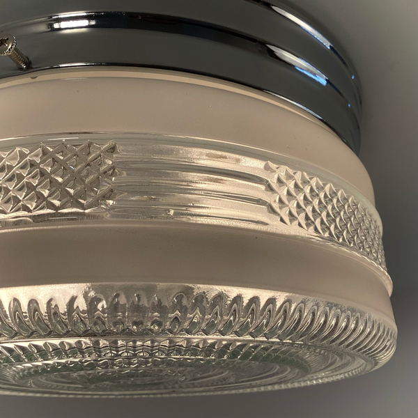 Vintage post-war flush mount ceiling light with clear pressed glass shade and chrome base. 