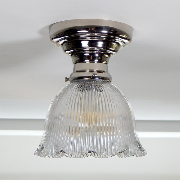 The antique semi-flush ceiling light features a Holophane glass shade and a thick polished nickel-plated ceiling light has been restored, detailed, cleaned, and is ready to install for your convenience. Available at www.vintporium.com