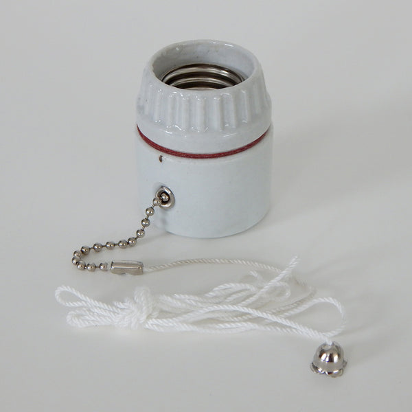 Medium base porcelain pull chain socket commonly found in vintage ceiling lights and sconces. The socket comes with a cloth cord extension and adjustable bead chain stop. Available at www.vintporium.com