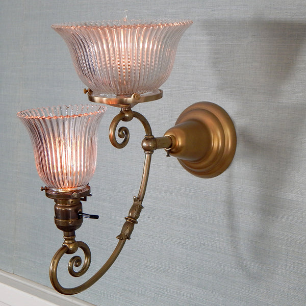 This renovated antique Victorian-era electric sconce has been rewired with numerous new parts added. Circa 1905ish, its naturally aged brass finish emphasizes its age and unique character. The fixture features new wiring, sockets, etc., and has been cleaned, yet not overly detailed. The sconce comes with mounting hardware making it convenient to install. Available at www.vintporium.com